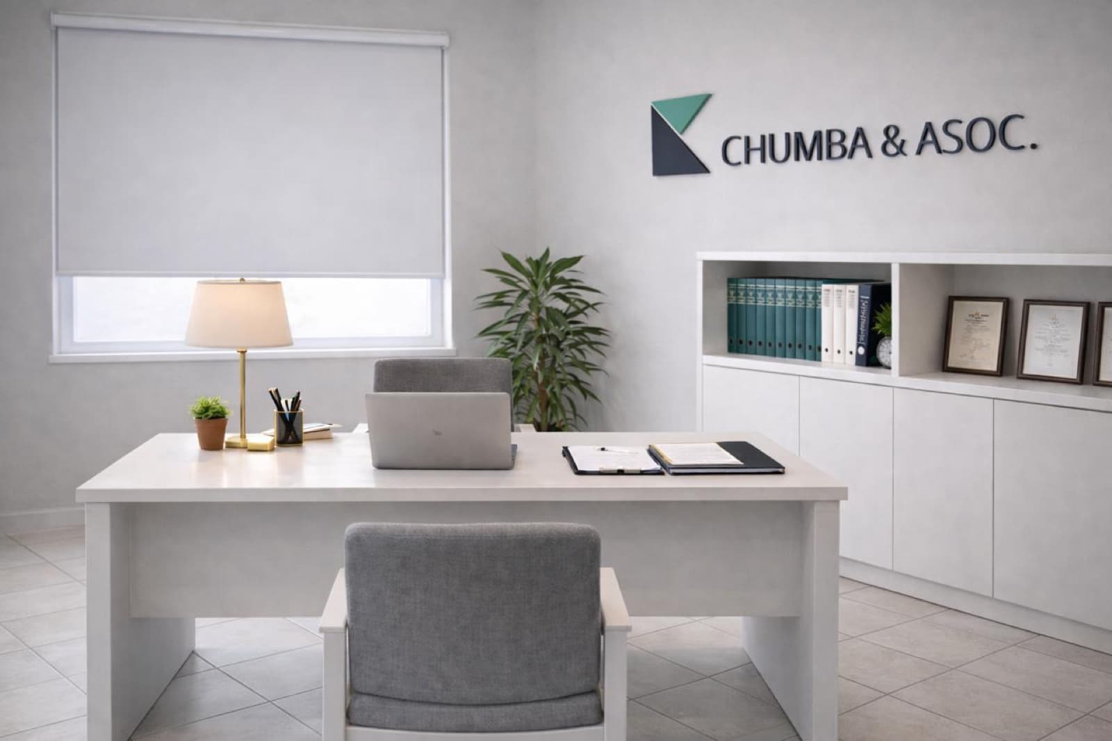 Sede del estudio en Wilde: escritorio de atención con la silla del consultante en primer plano, el logo Chumba & Asoc. en la pared y la biblioteca de códigos con los diplomas enmarcados